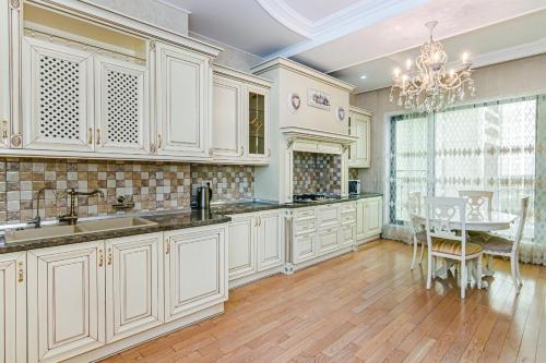 a large kitchen with white cabinets and a table at Mc Donalds Hotel Apartment Nizami Street in Baku