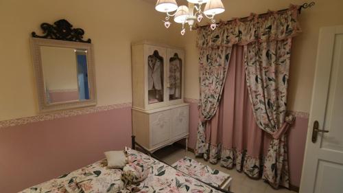 sypialnia z łóżkiem, lustrem i zasłonami w obiekcie La casina dei cuori di nonna Miglia w mieście Pallerone