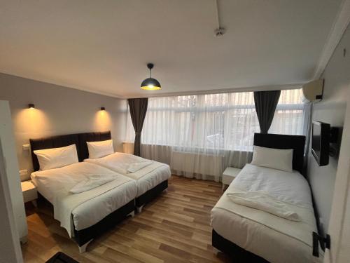 um quarto com 2 camas e uma janela em Asparagus HOTEL & SUITES OLD CITY em Istambul