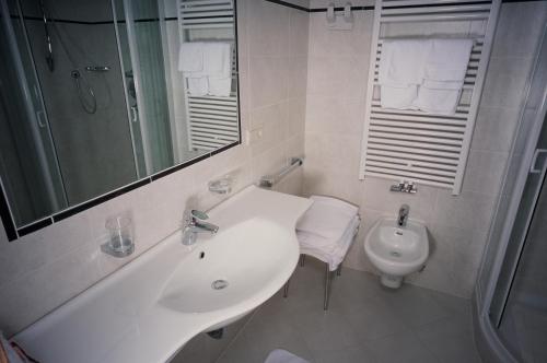 a white bathroom with a sink and a toilet at Residence Frea in Selva di Val Gardena
