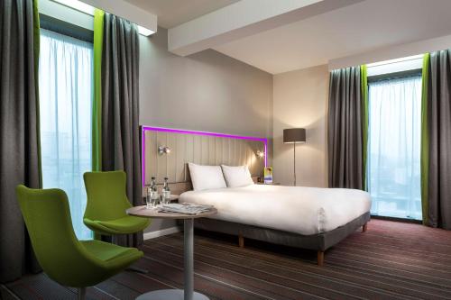 Habitación de hotel con cama, mesa y sillas en Park Inn by Radisson Manchester City Centre, en Mánchester