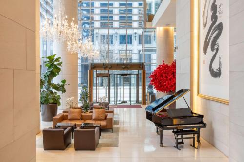 een lobby met een piano en een woonkamer bij Shangri-La Vancouver in Vancouver