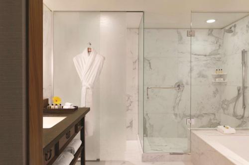a bathroom with a shower and a robe on a rack at Shangri-La Vancouver in Vancouver