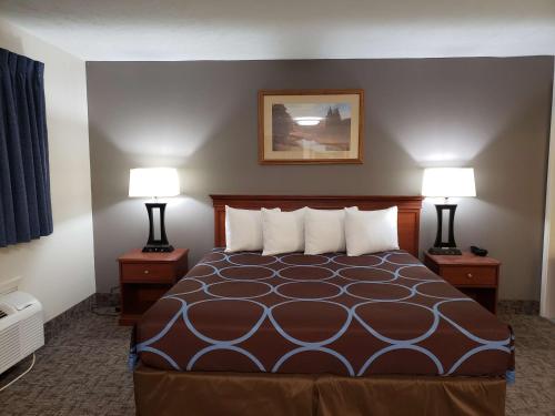 a hotel room with a bed with two lamps at SureStay Plus Hotel by Best Western Grand Island in Grand Island