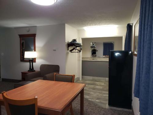 a living room with a table and a refrigerator at SureStay Plus Hotel by Best Western Grand Island in Grand Island