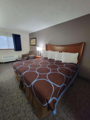グランドアイランドにあるSureStay Plus Hotel by Best Western Grand Islandの大きなベッドとソファのあるホテルの部屋