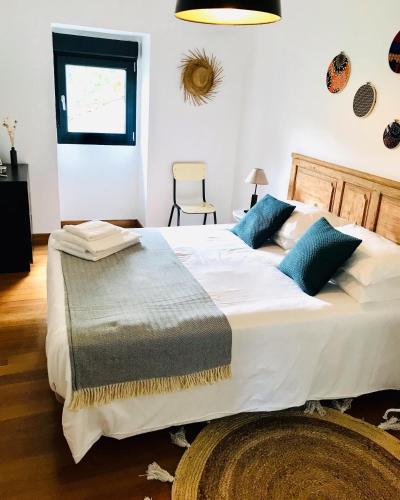 1 dormitorio con 1 cama blanca grande con almohadas azules en Casa 1883 