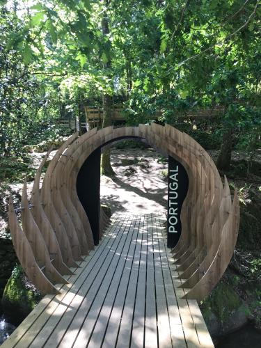 a wooden bridge over a path in a park at Casa 1883 in Cevide