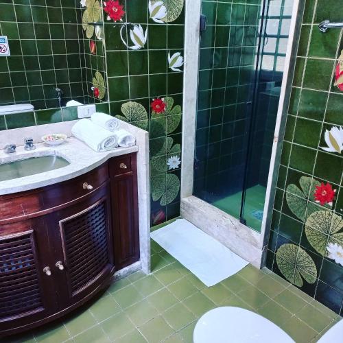 a bathroom with a sink and a shower at Pousada Solar Azul in Miguel Pereira
