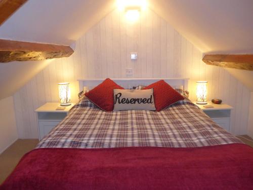 een slaapkamer met een bed met rode kussens bij Dolfor in Nefyn