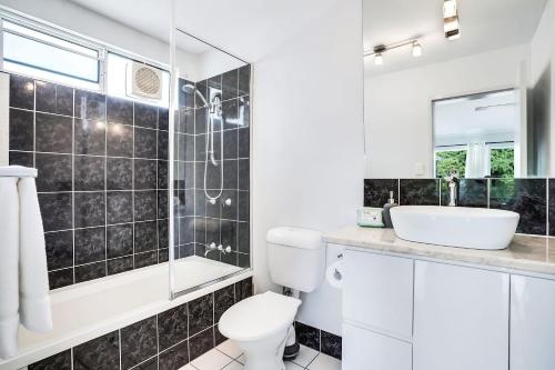 W łazience znajduje się toaleta, umywalka i lustro. w obiekcie Leumeah - A Modern Townhouse in Cairns w mieście Cairns North