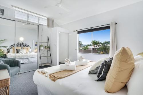 sypialnia z dużym białym łóżkiem i dużym oknem w obiekcie Leumeah - A Modern Townhouse in Cairns w mieście Cairns North