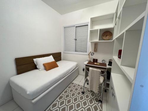 Un dormitorio pequeño con una cama y un escritorio. en Casatempo Moradas Pelotas Quartier proximo hospital Unimed, en Pelotas