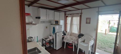 a kitchen with a refrigerator and a table and chairs at Ellas y Marú in La Paloma