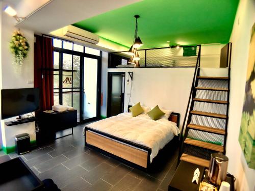 una camera con letto e soffitto verde di Carefree Homestay a Gukeng