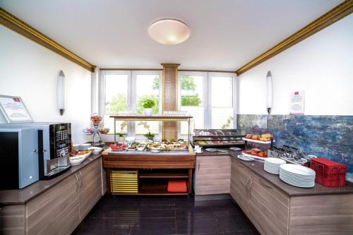 a large kitchen with a buffet of food at Hotel City Panorama in Hannover