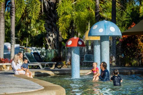a group of children playing in a fountain with mushrooms at BIG4 Adventure Whitsunday Resort in Airlie Beach