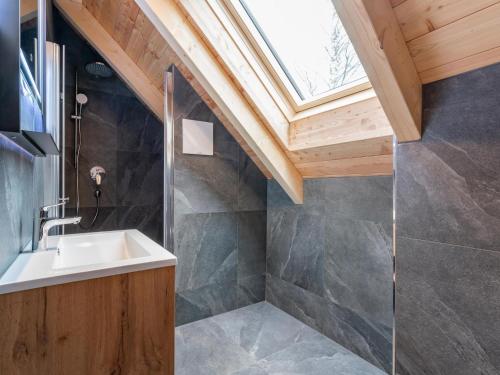 a bathroom with a sink and a skylight at Mountain Chalet Alpinchique 2 in Sankt Lorenzen ob Murau