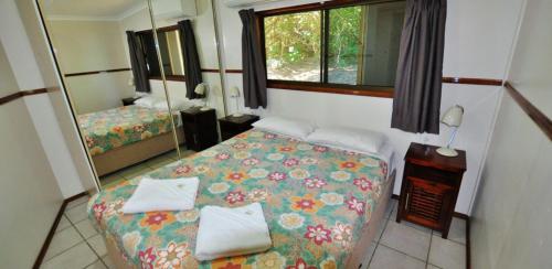 a small bedroom with a bed and a mirror at Cape Hillsborough Nature Tourist Park in Seaforth