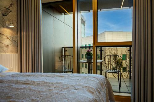 a bedroom with a bed and a large glass window at Fillhus Apartments in Poznań