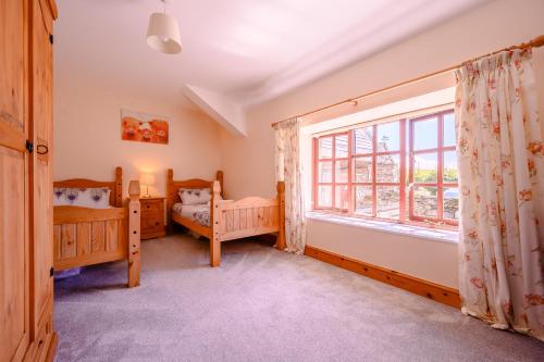 ミロムにあるTower Cottageのベッドルーム1室(ツインベッド2台、窓付)
