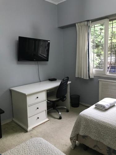 um quarto com uma secretária e uma televisão na parede em Our home em Florida