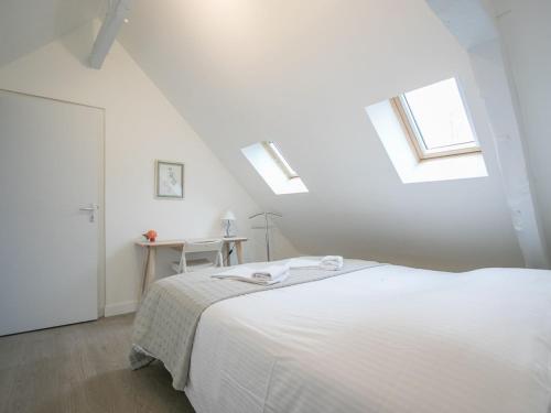 a white bedroom with a white bed and skylights at Calm and comfortable apartment in Bayeux, 9km from the beach in Bayeux