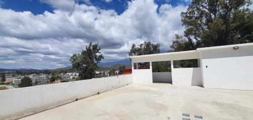 una casa blanca con una pared blanca y árboles en De León Huehuetenango en Las Victorias