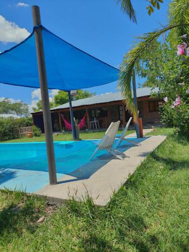 un ombrellone blu e una sedia accanto alla piscina di Hostel Raíces Salta a Salta