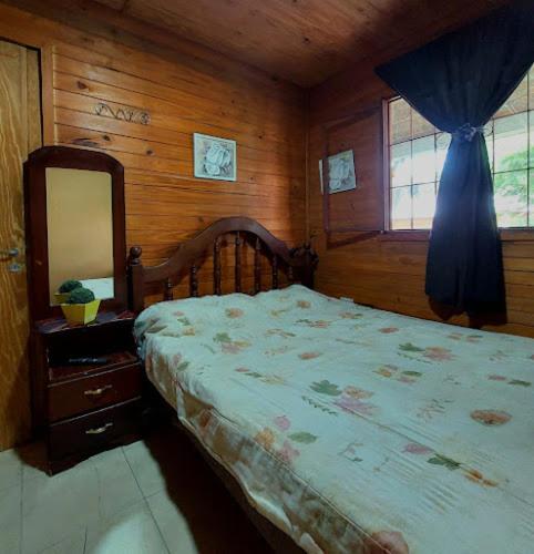 a bedroom with a bed with a dresser and a mirror at Hostel Raíces Salta in Salta