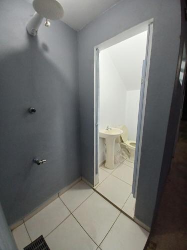 a bathroom with a toilet and a sink at Pequeno apartamento em chacara próximo às praias com internet in São Francisco do Sul