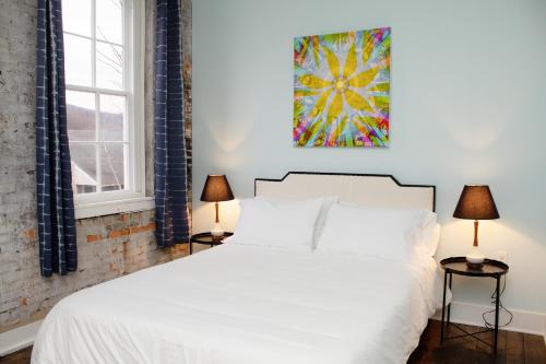 a bedroom with a white bed and two lamps at Bischoff Inn - Former 1870 Furniture Factory Now 5 Room Boutique Hotel 