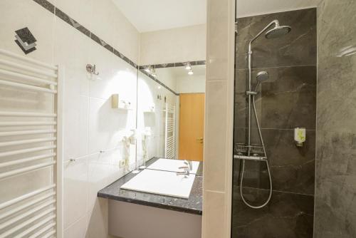 a bathroom with a sink and a shower at Hotel Opal in Hannover