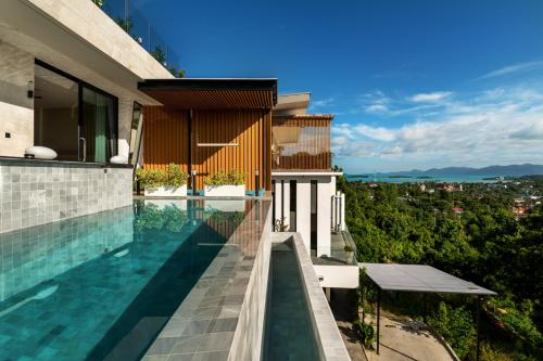 a swimming pool on the side of a house at Magic suites Seaview villas, Koh Samui in Choeng Mon Beach