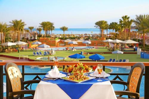 a table with a plate of food and wine glasses at a resort at Gafy Resort Aqua Park in Sharm El Sheikh