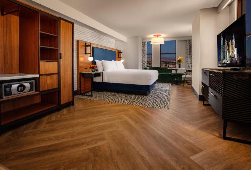 a hotel room with a bed and a flat screen tv at New York-New York in Las Vegas