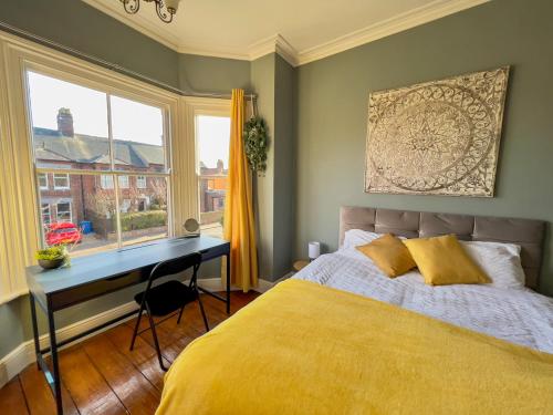 um quarto com uma cama, uma secretária e uma janela em Stylish 4 bed house with parking in central Norwich em Norwich