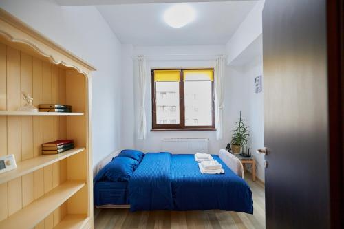 Un pequeño dormitorio con una cama azul y una ventana en Alessandro Home 3 Luxury Centru Palas Mall Iași Lazăr Residence en Iaşi