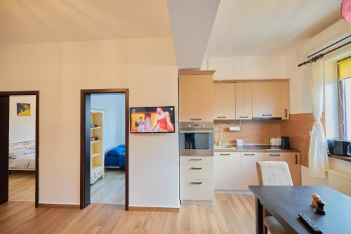 a kitchen with white cabinets and a table in a room at Alessandro Home 3 Luxury Centru Palas Mall Iași Lazăr Residence in Iaşi