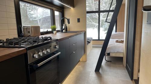 a kitchen with a stove top oven next to a window at Micro maison le Nordik in Saint Zenon