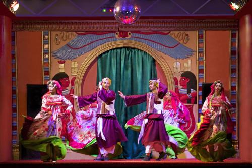 a group of women in colorful costumes on a stage at Gafy Resort Aqua Park in Sharm El Sheikh