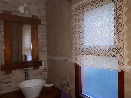 baño con cortina blanca, lavabo y ventana en Las Nenas. Un paraíso en el bosque en Balneario Mar Azul