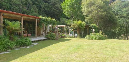 dom z ogrodem i podwórko z domem w obiekcie Blackfern Lodge w mieście Waimiha