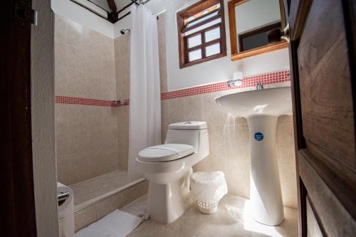 y baño con aseo, lavabo y ducha. en Hotel Villa Luna, en Villa de Leyva