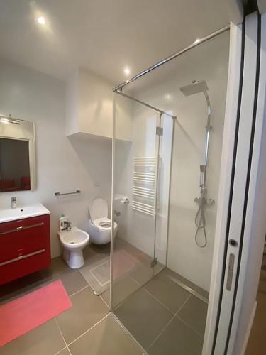 une salle de bain avec une douche en verre et des toilettes dans l'établissement Modern Apartment in the Heart of St-Germain, à Paris