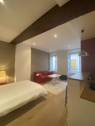 - une chambre avec un lit et un canapé rouge dans l'établissement Modern Apartment in the Heart of St-Germain, à Paris