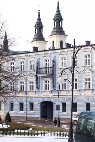un gran edificio blanco con una puerta delante en Pod Ratuszem, en Wieluń