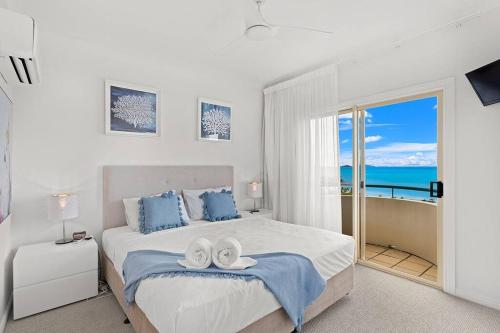 a bedroom with a bed with two towels on it at Aqua Vista in Airlie Beach