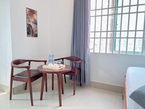 a room with a table and two chairs and a window at White Corner Hotel in Phnom Penh