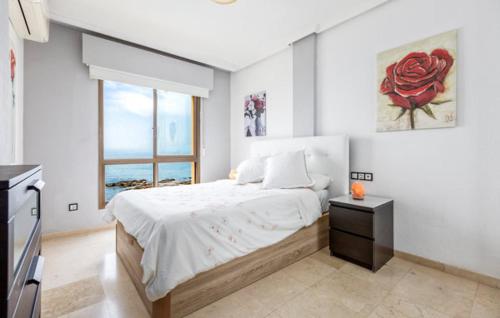 ein Schlafzimmer mit einem Bett mit einer roten Rose an der Wand in der Unterkunft Surf house in Benalmadena Costa